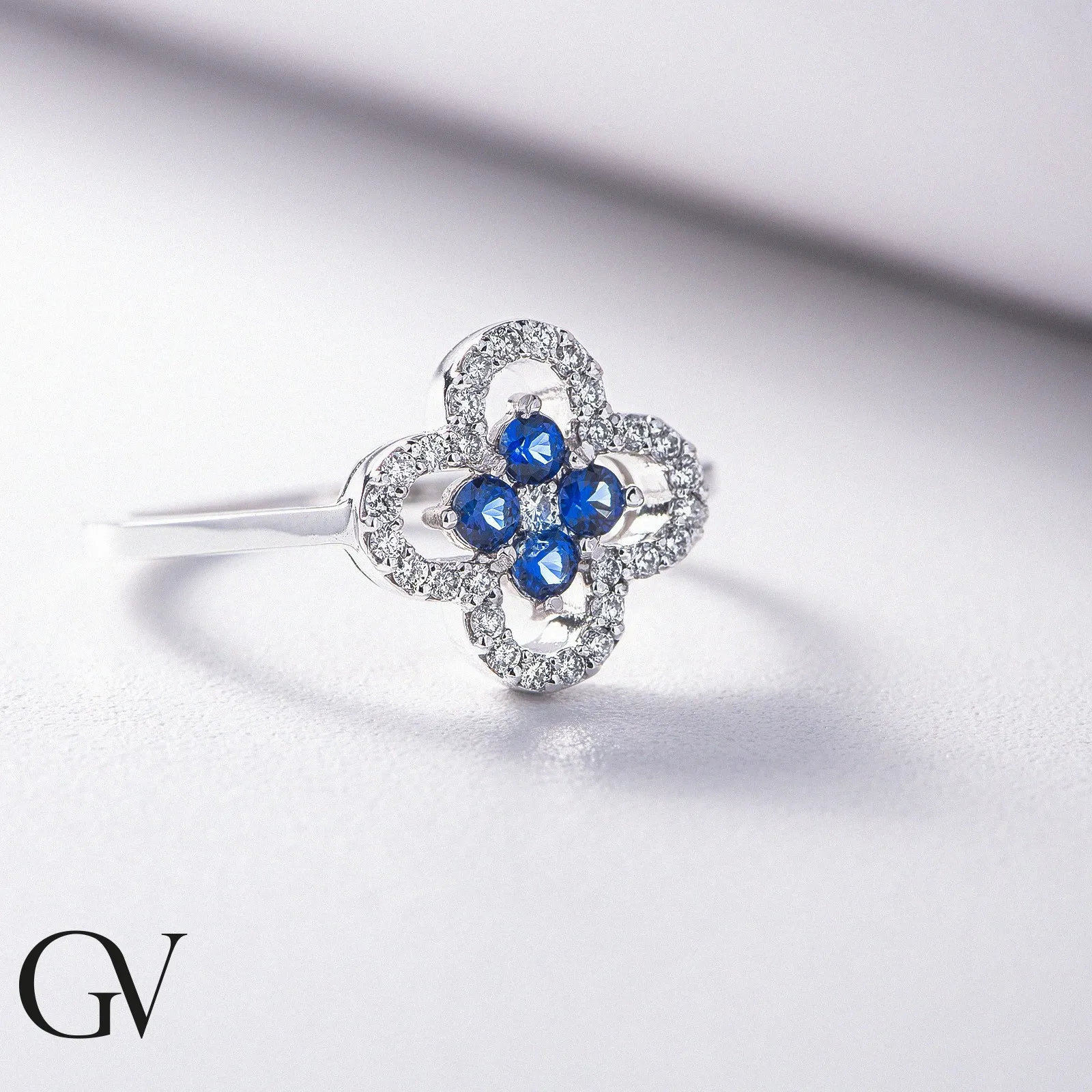 Anello in oro bianco 18k con diamanti e zaffiri blu nella parte centrale.